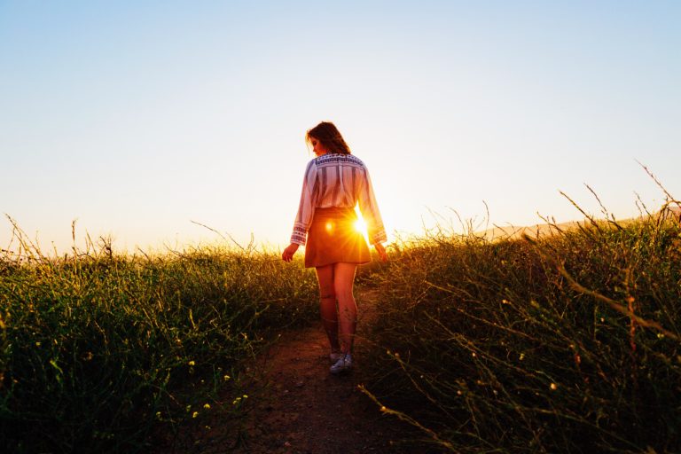 Une femme marche au milieu de champs